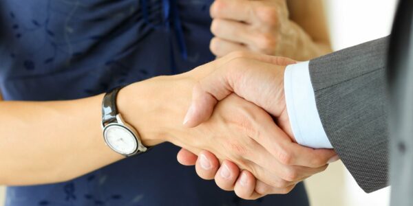 Businessman And Woman Shake Hands As Hello In Office Closeup Businessman and woman shake hands as hello in office closeup. Friend welcome, introduction, greet or thanks gesture, product advertisement, partnership approval, arm, strike a bargain on deal concept
